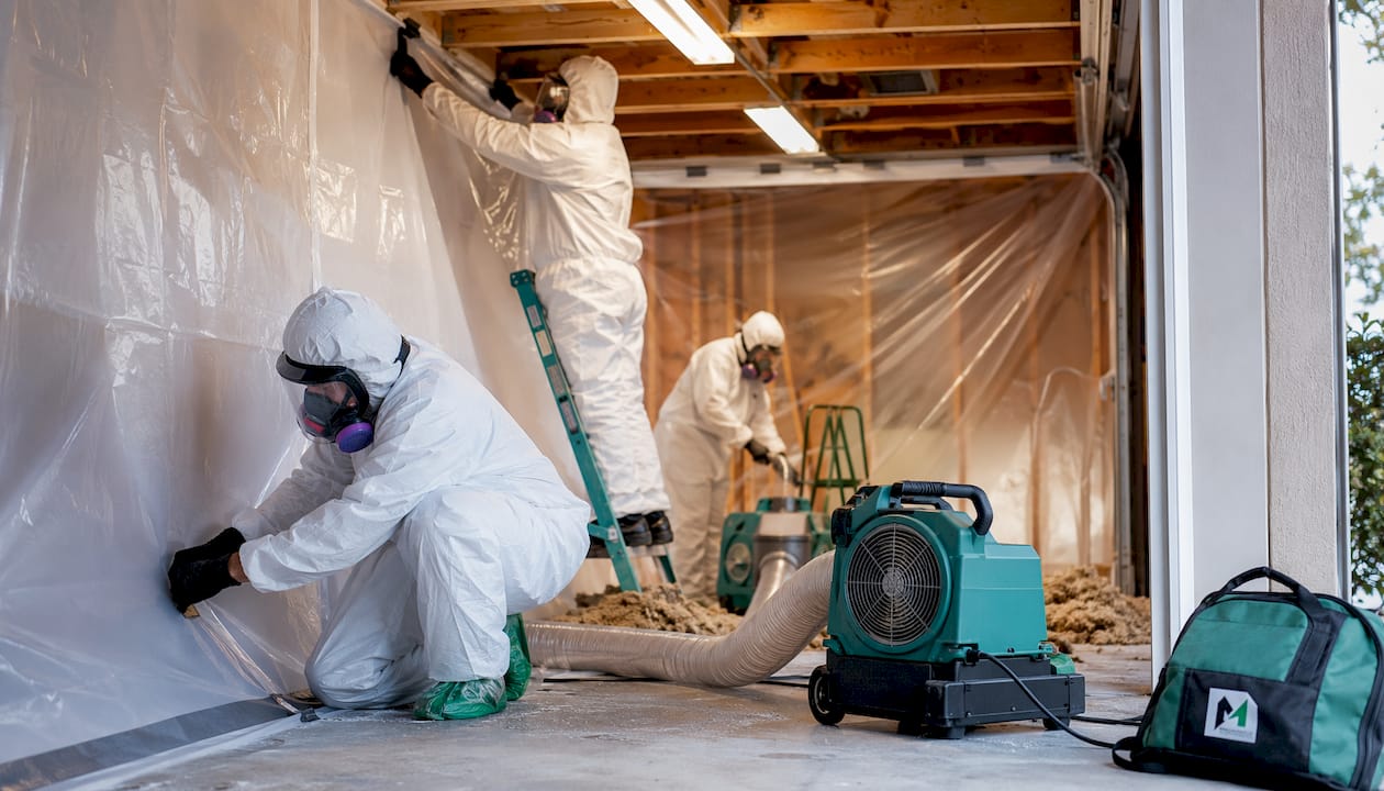 Asbestos abatement team preparing attic containment