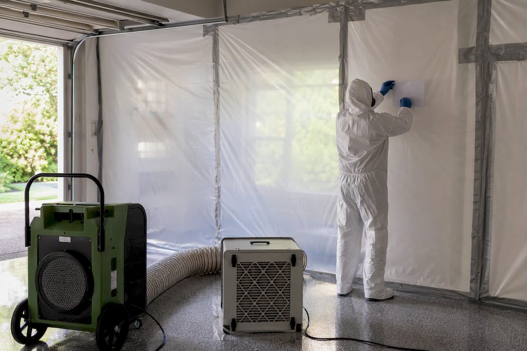Technician setting up asbestos containment zone
