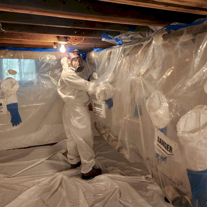 worker with tyvek suit doing asbestos removal