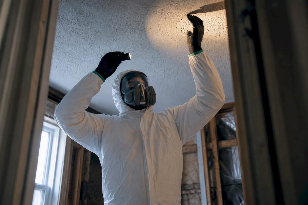 Technician inspecting suspect asbestos material